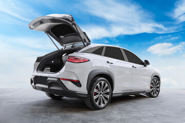 White Electric SUV with Open Rear Trunk parked in a parking lot under the sky.