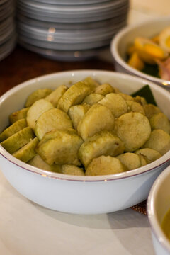 Close up of lontong sliced rice cake in bowl. Traditional Indonesian food made from compressed rice, served as side dish in Asian cuisine and street food meals.