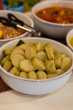 Close up of lontong sliced rice cake in bowl. Traditional Indonesian food made from compressed rice, served as side dish in Asian cuisine and street food meals.