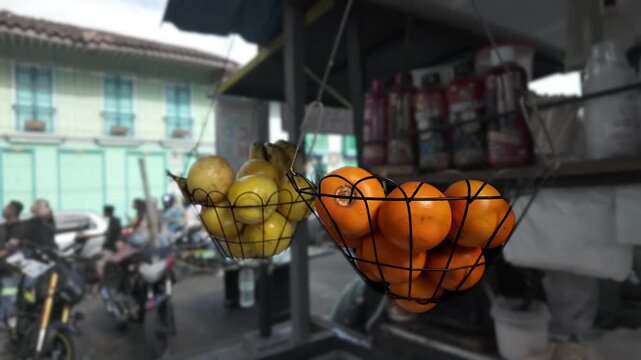 fresh fruit baskets hanging at a street food cart in colombia