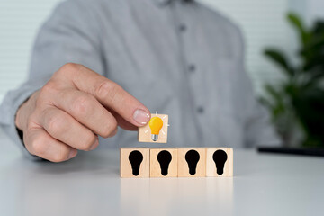 Hand Selecting Bright Idea on Wooden Blocks for Innovation Concept © jittawit21