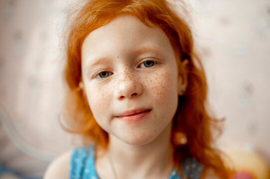 Smiling redhead girl with freckles on face