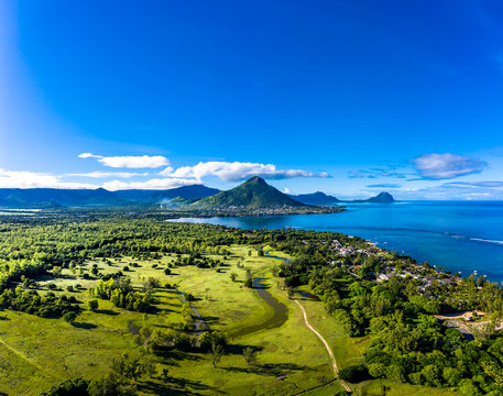 Mauritius, Black River, Flic-en-Flac, Aerial view of blue sky over coastal village in summer with Tourelle du Tamarin mountain in distant background