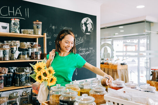 Smiling customer shopping in zero waste grocery store