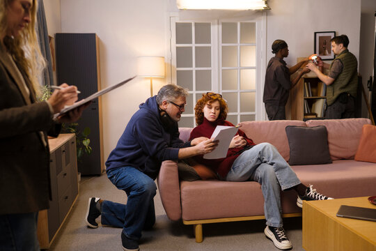 Director and crew prepare an actress for a video shoot indoors