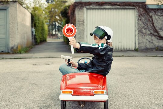 Boy in pedal car dressed up as policeman