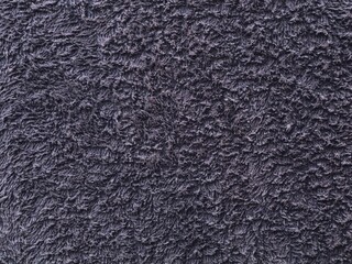A detailed macro shot showing the soft, looped texture of a dark grey terry cloth towel fabric, perfect for background use, textiles, fashion, or spa concepts © Eka