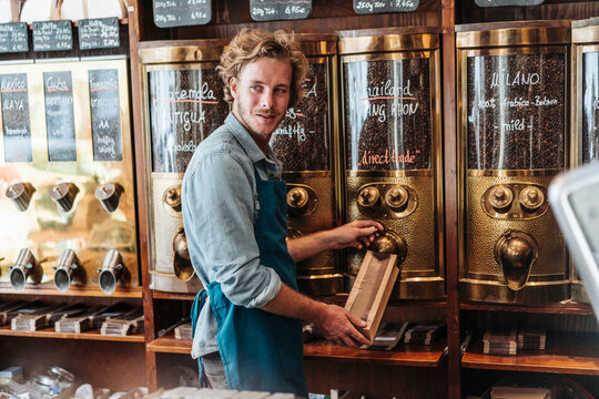 Coffee roaster in his shop filling bag with coffee