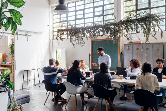 Businessman discussing with multiracial colleagues at workplace
