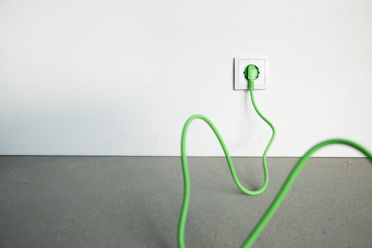 Close-up plug with cable in outlet at home under construction