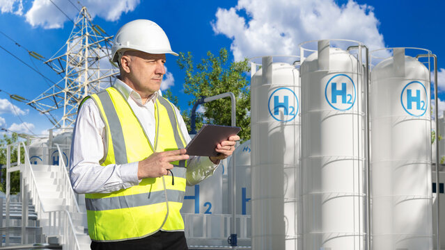 Hydrogen plant. Engineer inspects hydrogen storage tanks and power infrastructure with a tablet, supporting renewable energy production, industrial safety and clean hydrogen operations.