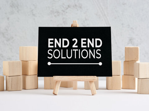Chalkboard displaying end to end solutions with wooden blocks