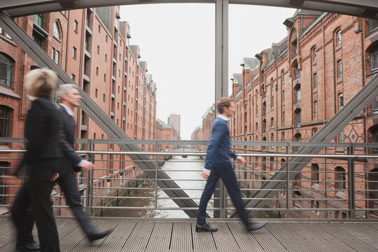 Commuters walking fast on a bridge in the city