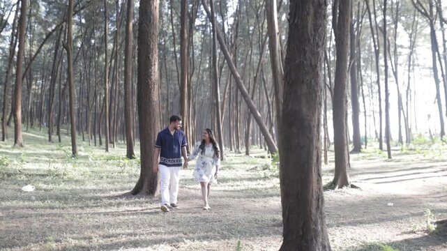 Romantic Couple Walking Together in a Serene Pine Forest During Daylight