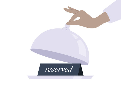Restaurant table booking system, a waiters hand lifting a cloche, revealing a reserved sign on a tray