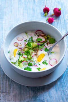 Cold cucumber soup with kefir and yogurt, summer light salad with mint, eggs, onion and herbs. Traditional Greek and Balkan cuisine, Tarator, Tzatziki. Healthy, vegetarian, diet, low calorie, soup
