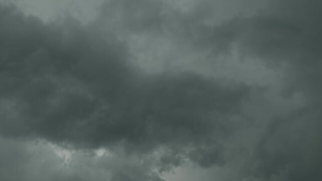 A low-angle shot of dark, heavy storm clouds gathering in a gloomy sky before a rain.