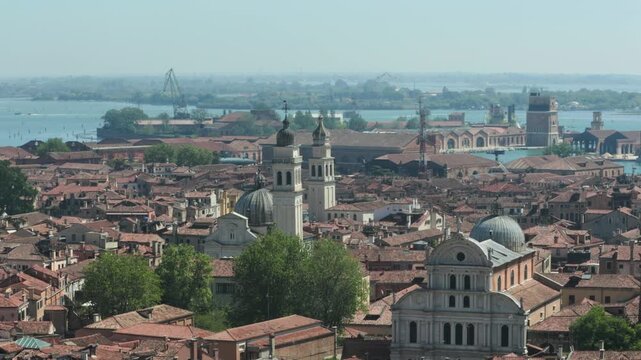 An aerial view sweeps over ancient terracotta rooftops and majestic domed churches toward the blue Venetian lagoon. Such vibrant historic cityscapes inspire unforgettable European summer vacations.