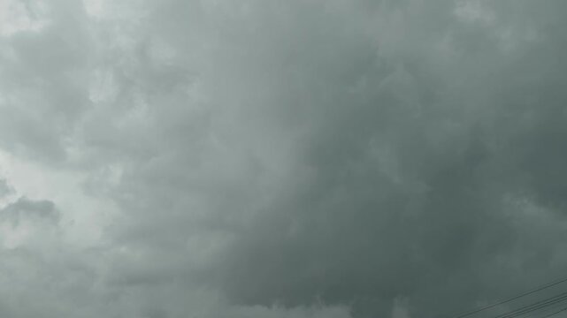 A low-angle shot of dark, heavy storm clouds gathering in a gloomy sky before a rain.