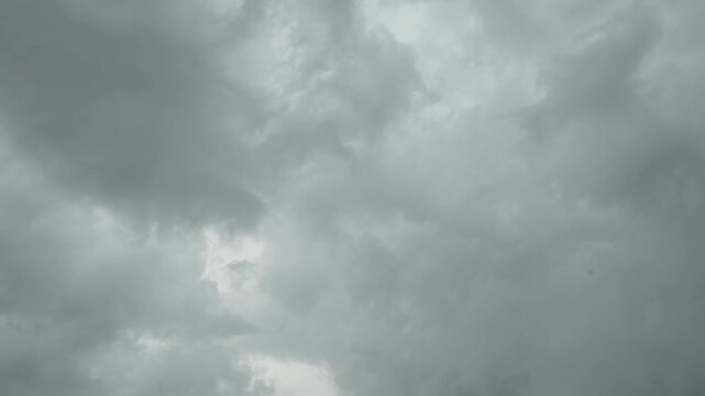 A low-angle shot of dark, heavy storm clouds gathering in a gloomy sky before a rain.