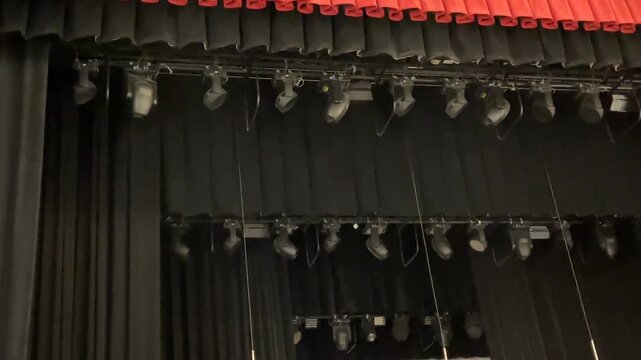 Stage curtains and lighting setup in a theater, showcasing a vibrant red and black theme