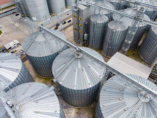 Grain storage facilities with silos and machinery in an agricultural area during daylight © DSMT