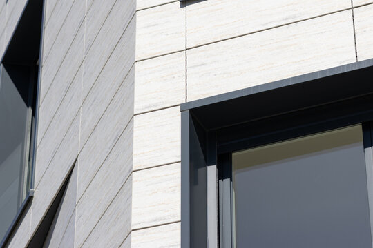 architectural detail of a modern ventilated facade with panels and dark window frames