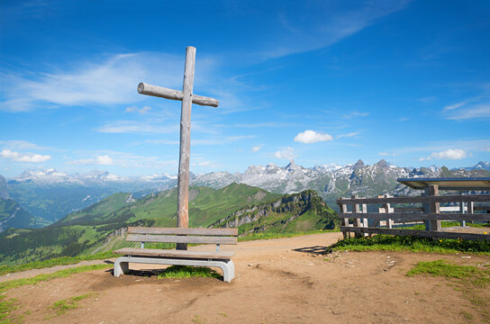 mountain cross Fronalpstock with wooden bench, hiking destination Schwyz, switzerland