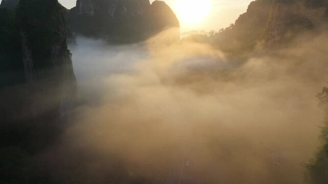 Aerial view of a scenic road through limestone karst mountains and morning mist in Krabi, Thailand