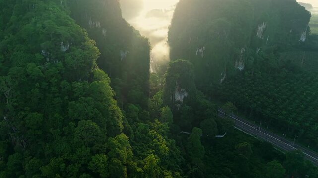 Aerial view of a scenic road through limestone karst mountains and morning mist in Krabi, Thailand