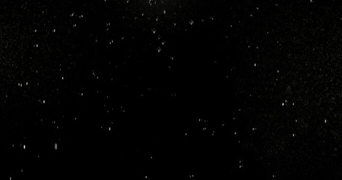 Realistic rain streaks isolated on a black background creating a realistic weather overlay with dynamic falling droplets perfect for visual effects compositing graphic design.