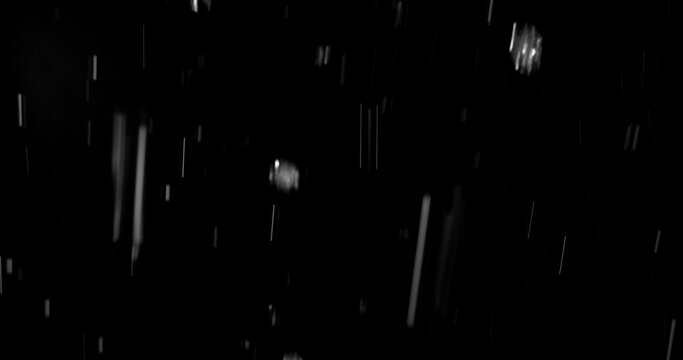 Realistic rain streaks isolated on a black background creating a realistic weather overlay with dynamic falling droplets perfect for visual effects compositing graphic design.
