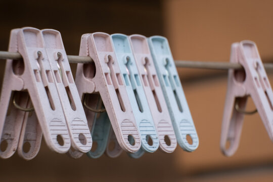 Clothes pegs hang on a line in a backyard during a sunny afternoon