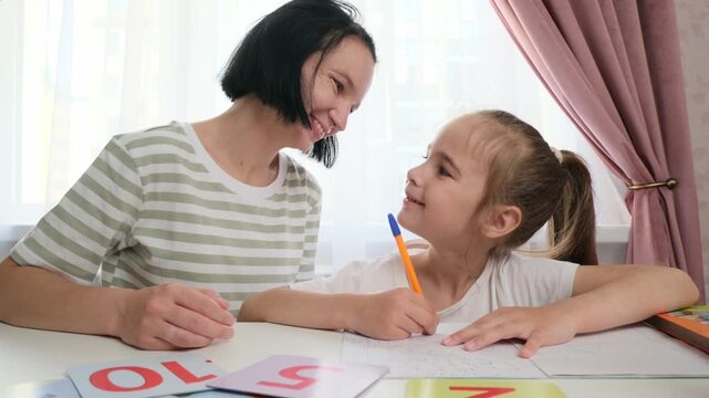 Mother helping child build self confidence during home learning process