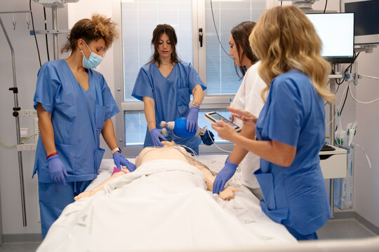 Nursing students training cpr on medical mannequin simulation
