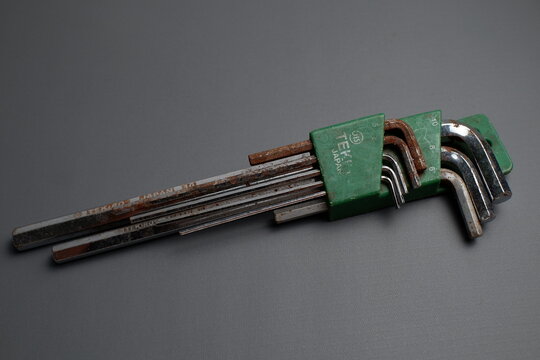 Satu set kunci L (allen key) merek Tekiro dalam wadah hijau yang tampak usang dan berkarat di atas latar belakang abu-abu gelap.