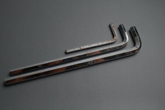 Three chrome-plated star keys (Torx keys) are laid out side-by-side against a minimalist dark gray background.