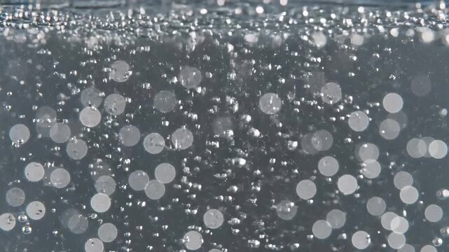 Lively carbonation stream with brilliant reflections in transparent fluid texture, showing fluid dynamic motion and optical purity, ideal for beverage advertising, science visualization