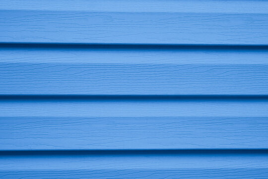 Blue siding texture with horizontal lines and wood grain