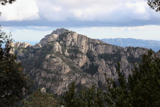Limestone mountainside naturally framed by trees in Els Ports, Spain