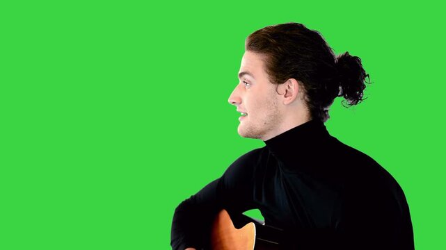 Talented guy plays fingerstyle guitar and sings on a Green Screen, Chroma Key.