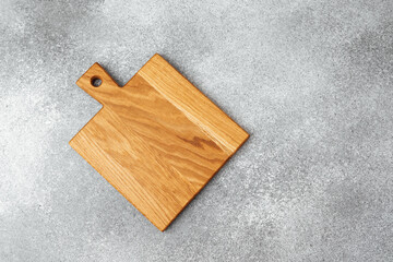 Fototapeta premium Wooden cutting board on a gray surface ready for meal preparation