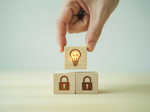 Hand placing a light bulb wooden block