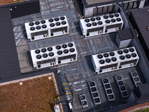 Aerial view of data center roof featuring multiple industrial HVAC cooling units and fans arranged on a modern building structure in Gdansk, Poland.