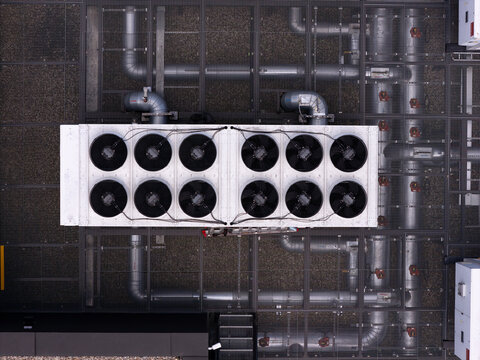 Aerial view of data center cooling units with industrial pipes and ventilation fans on a rooftop in Gdansk, Poland.