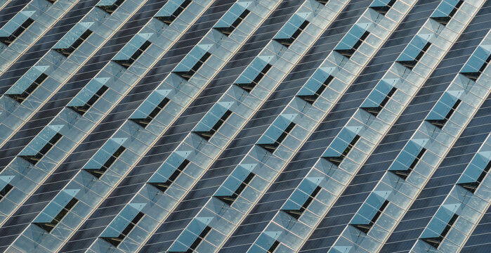 Aerial view of agrivoltaic greenhouse rooftops featuring integrated photovoltaic solar panels and ventilation skylights in Saulce-sur-Rhone, Auvergne-Rhone-Alpes, France.