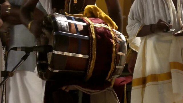 Closeup of an artist playing Thavil (Thakil), a South Indian percussion musical instrument during the night procession in a temple festival in Kerala, India