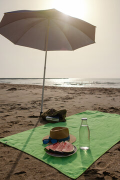 Vertical beach umbrella with fresh watermelon and beach accessories