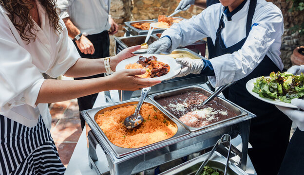 Catering staff serving Mexican food at an event buffet in Mexico Latin America, plate of mexican rice and sauces 