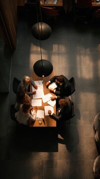 Multicultural business team meeting in a minimalist cafe, documents on table, focused discussion, cinematic lighting 